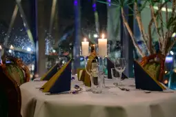 Elegancko nakryty stół w restauracji z świecami i dekoracjami.