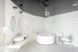 Nowoczesna łazienka z wanną z hydromasażem, podwójnymi umywalkami i eleganckim wykończeniem.