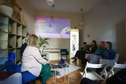 Spotkanie w Centrum Wczesnego Wspierania Rodzin, prezentacja na ścianie.