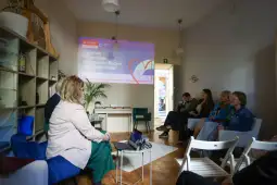 Spotkanie w Centrum Wsparcia Rodzin, prezentacja na ekranie, uczestnicy w sali.