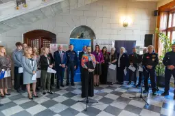 Uroczystość z udziałem przedstawicieli różnych instytucji i organizacji w eleganckim wnętrzu.