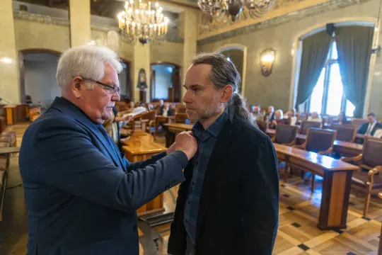 Ceremonia wręczenia odznaczenia w sali obrad.