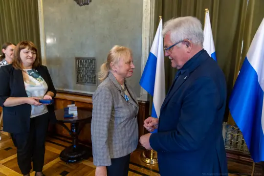 Wręczenie odznaczenia w obecności flagi i gości.