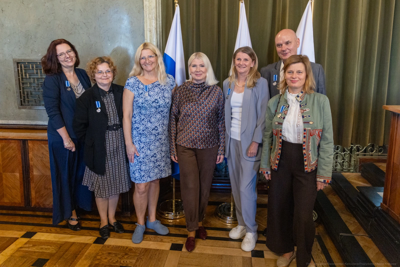Grupa osób w formalnych strojach, stojąca obok siebie, z odznaczeniami na piersiach.  Autor: Bogusław Świerzowski