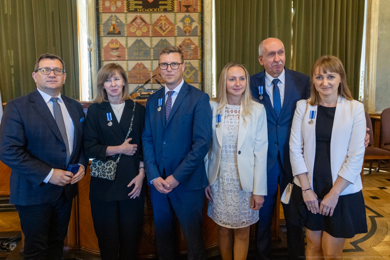 Grupa osób w formalnych strojach z odznaczeniami na piersiach.  Autor: Bogusław Świerzowski