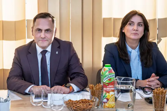 Mężczyzna i kobieta siedzą przy stole, obok szklanki i butelki soku.
