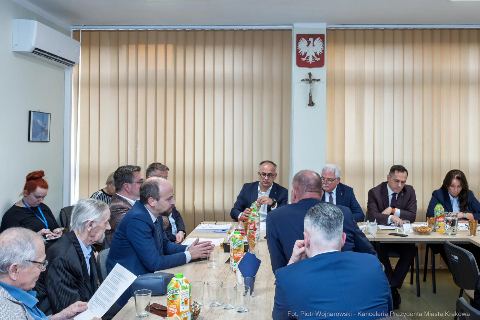 Spotkanie w sali konferencyjnej z uczestnikami przy stole, napoje i dokumenty na stole.  Autor: Piotr Wojnarowski