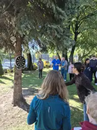 Gra w rzutki na świeżym powietrzu, uczestnicy skupieni na celu.