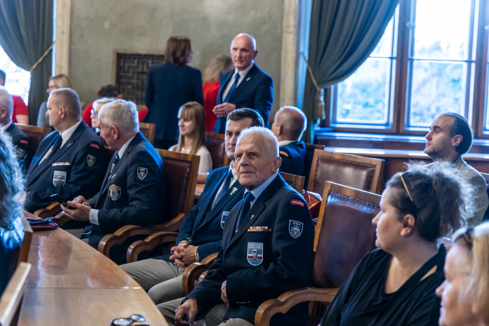 Grupa osób w mundurach siedzących przy stole w sali konferencyjnej.  Autor: Jan Graczyński