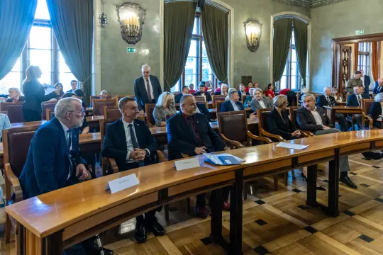 Spotkanie w sali konferencyjnej z uczestnikami siedzącymi przy stole.
