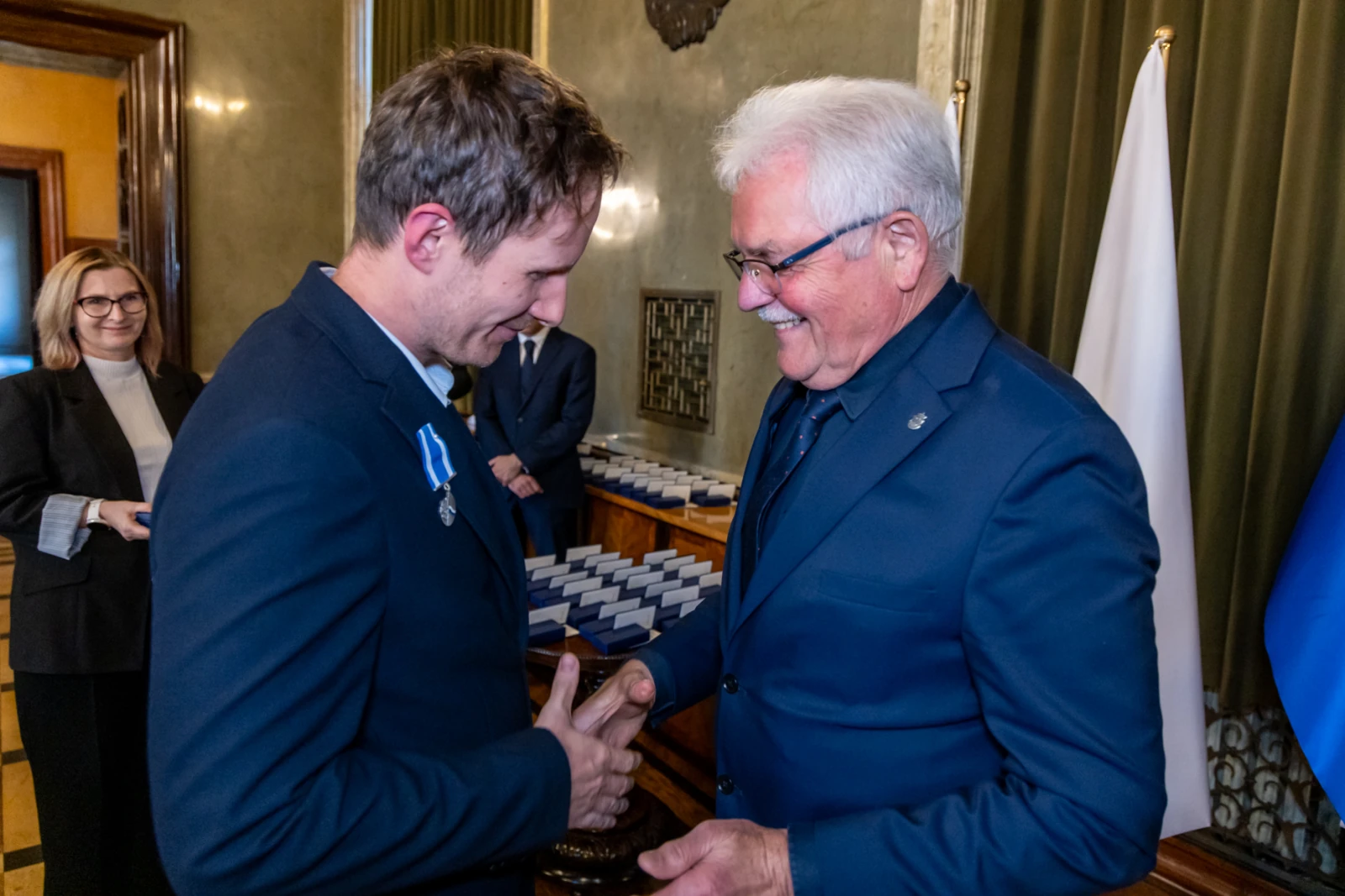 Uroczystość wręczenia odznaczeń, uściski dłoni, uśmiechy uczestników.  Autor: Jan Graczyński