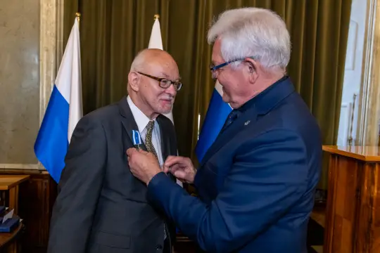 Uroczystość wręczenia odznaczenia mężczyźnie w garniturze.