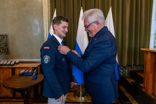 Wręczenie odznaczenia mężczyźnie w mundurze z napisem Polska.