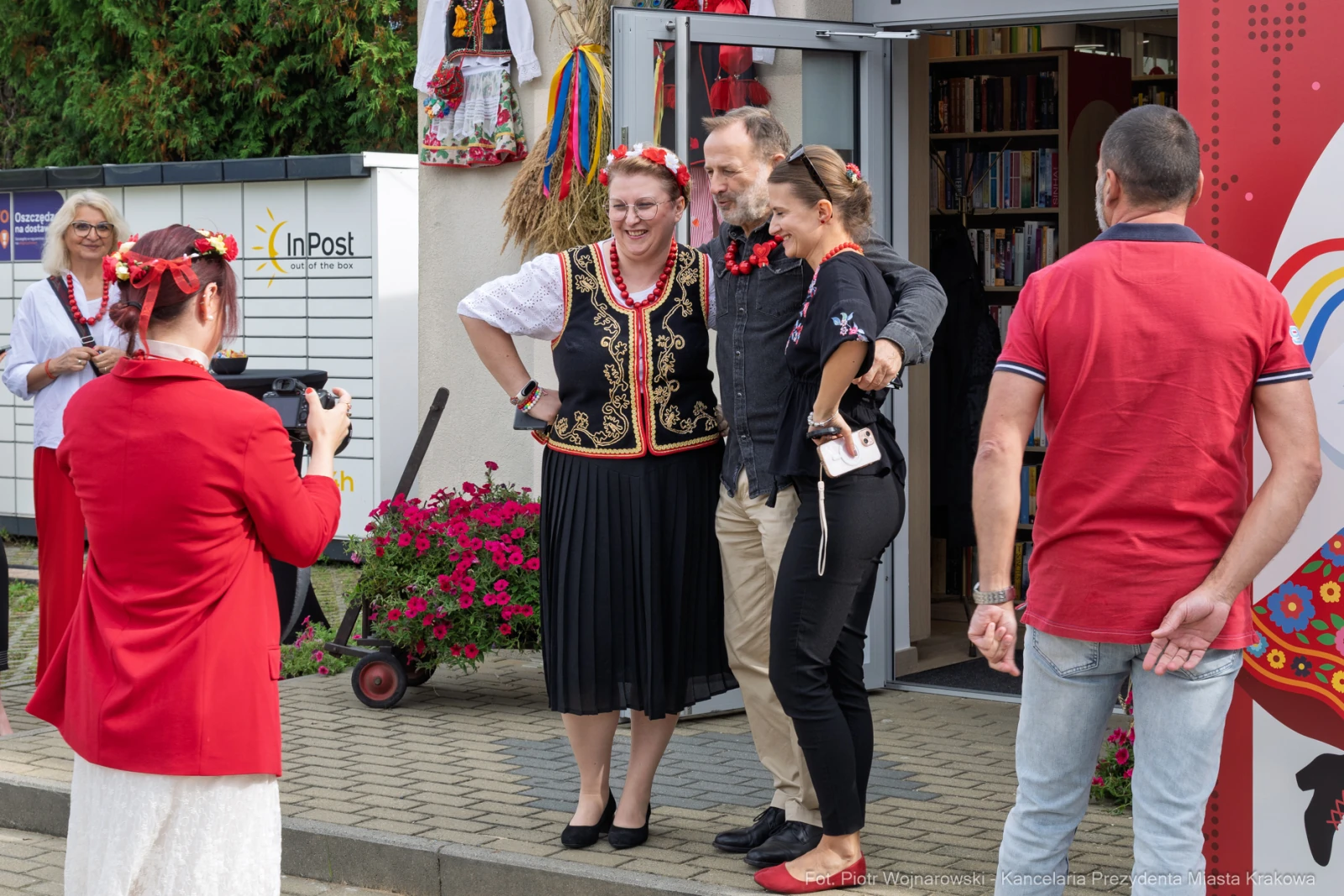 Grupa osób w tradycyjnych strojach, pozująca do zdjęcia na tle budynku.  Autor: Piotr Wojnarowski