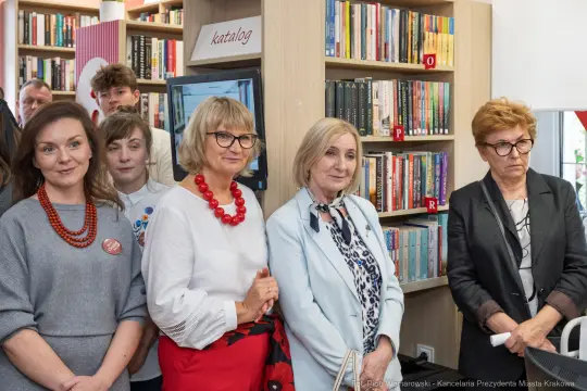 Grupa osób w bibliotece, uczestniczących w wydarzeniu kulturalnym.