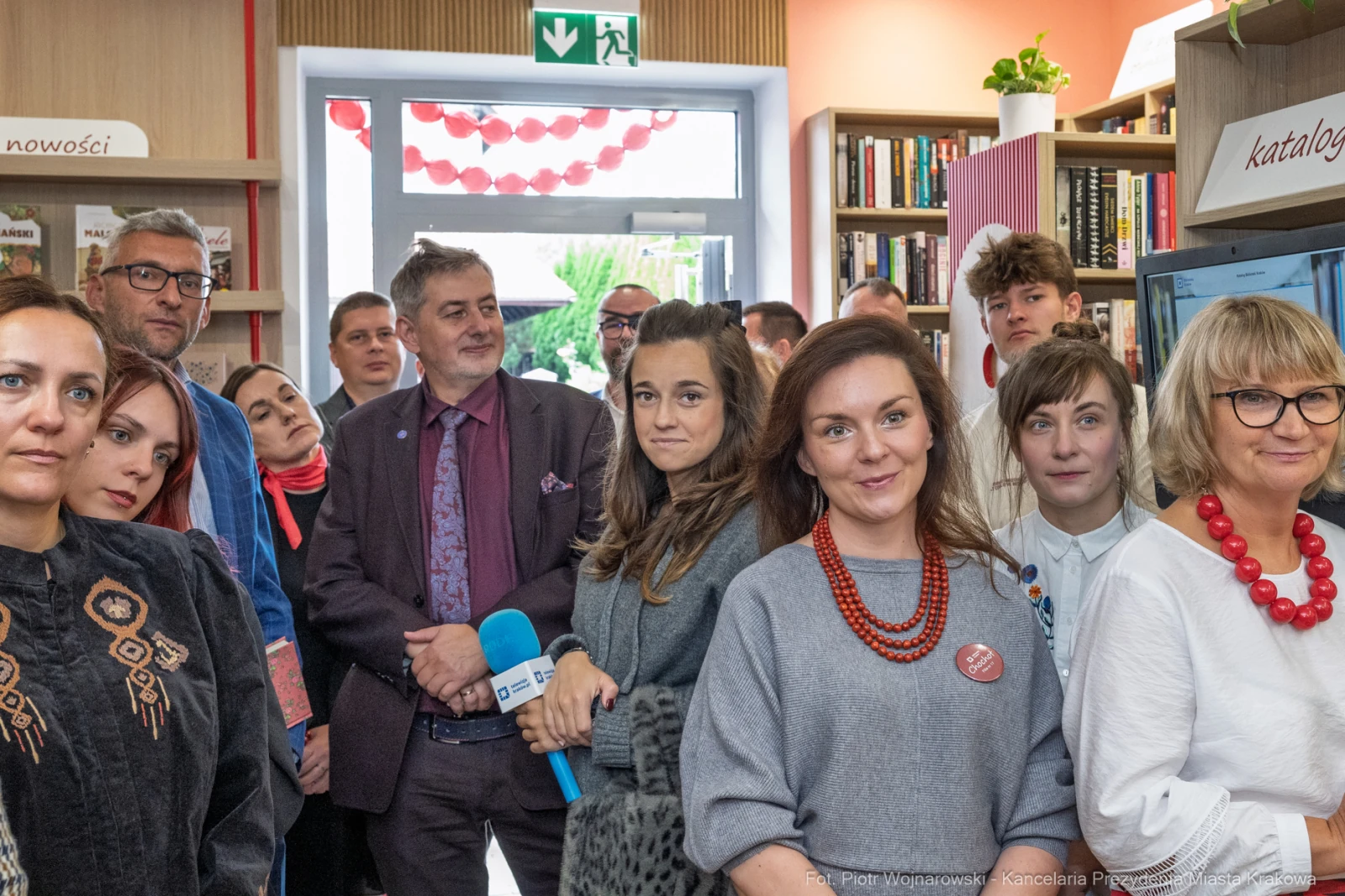 Grupa ludzi w bibliotece, niektórzy z mikrofonem, inni w rozmowie.  Autor: Piotr Wojnarowski