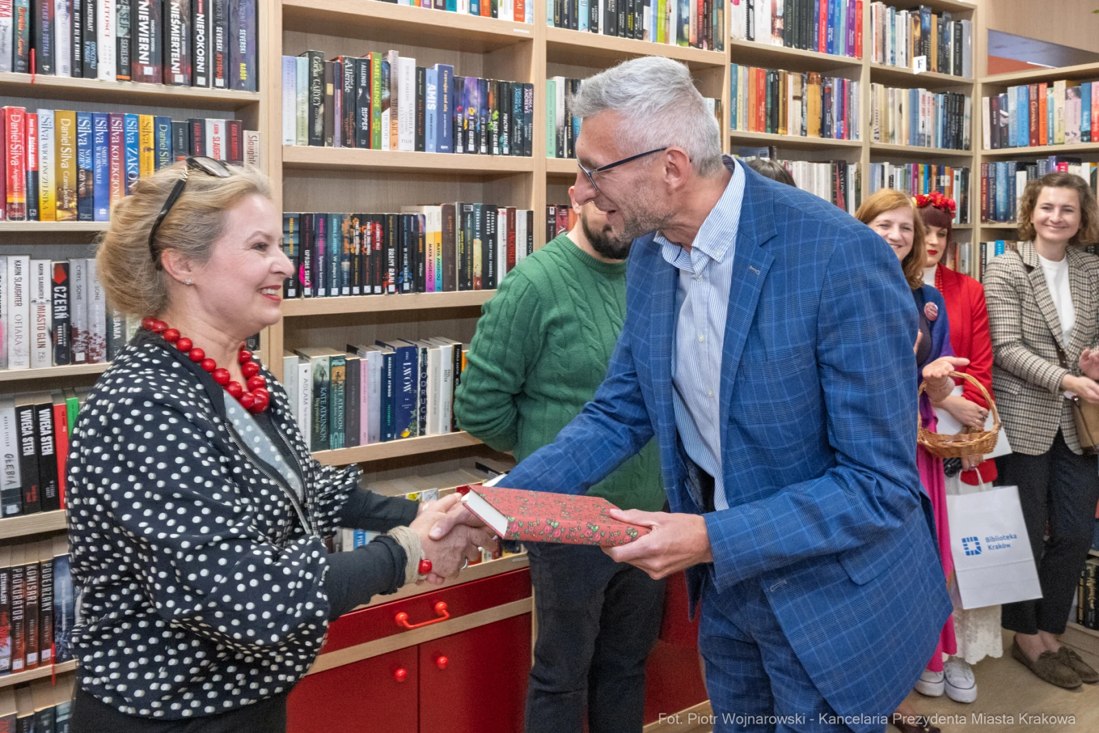 Wręczenie książki podczas wydarzenia literackiego w bibliotece.  Autor: Piotr Wojnarowski
