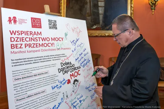 Mężczyzna podpisuje manifest kampanii przeciw przemocy wobec dzieci.