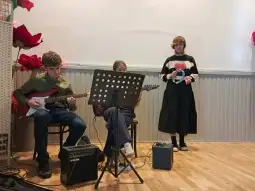 Młodzież grająca na instrumentach muzycznych podczas występu.