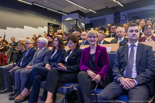 Grupa ludzi siedzących na widowni podczas wydarzenia.