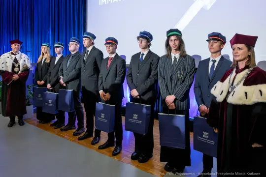 Uroczystość wręczenia dyplomów absolwentom z akademickimi czapkami.