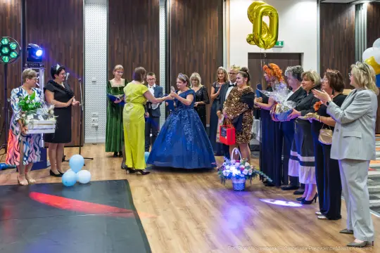 Uroczystość z balonami, kwiatami i prezentami, kobiety w eleganckich strojach.