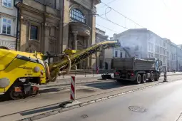 Maszyna do usuwania asfaltu i ciężarówka na ulicy w mieście.