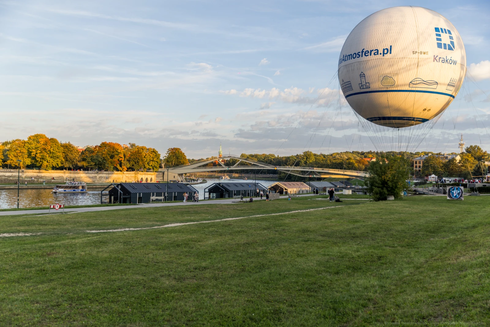 Balon na ogrzane powietrze nad rzeką, w tle most i zielona przestrzeń.  Autor: Bogusław Świerzowski