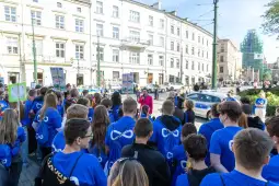 Tłum ludzi w niebieskich koszulkach podczas wydarzenia na ulicy.