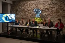 Konferencja prasowa z ośmioma osobami przy stole, z ekranem w tle i logo Boska Media.