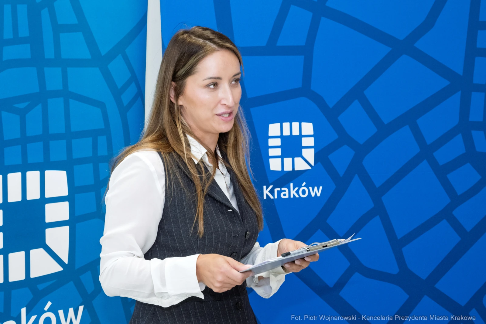Kobieta w eleganckim stroju prezentuje materiały w Krakowie.  Autor: Piotr Wojnarowski