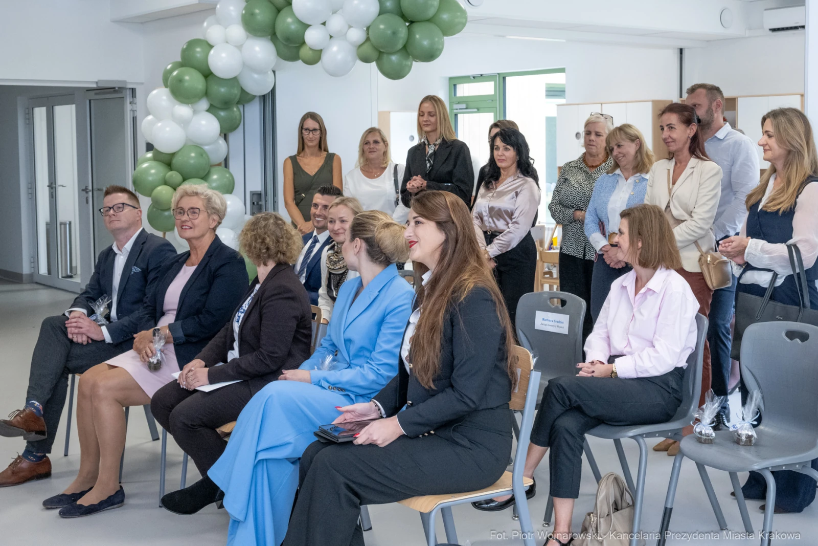 Grupa osób w eleganckich strojach podczas wydarzenia, w tle balony dekoracyjne.  Autor: Piotr Wojnarowski