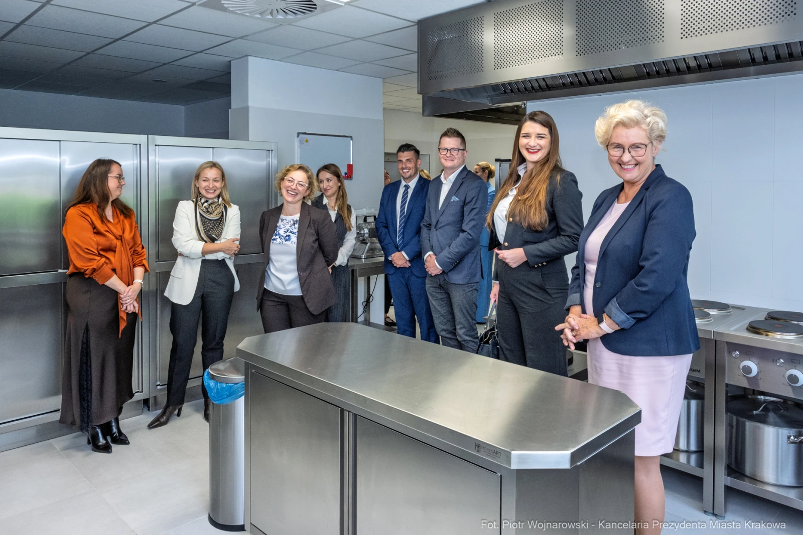 Grupa ludzi w nowoczesnej kuchni, uśmiechnięci, w trakcie spotkania.  Autor: Piotr Wojnarowski