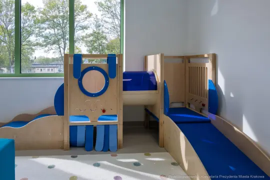 Nowoczesny kącik zabaw dla dzieci z drewnianymi elementami i kolorowymi akcentami.