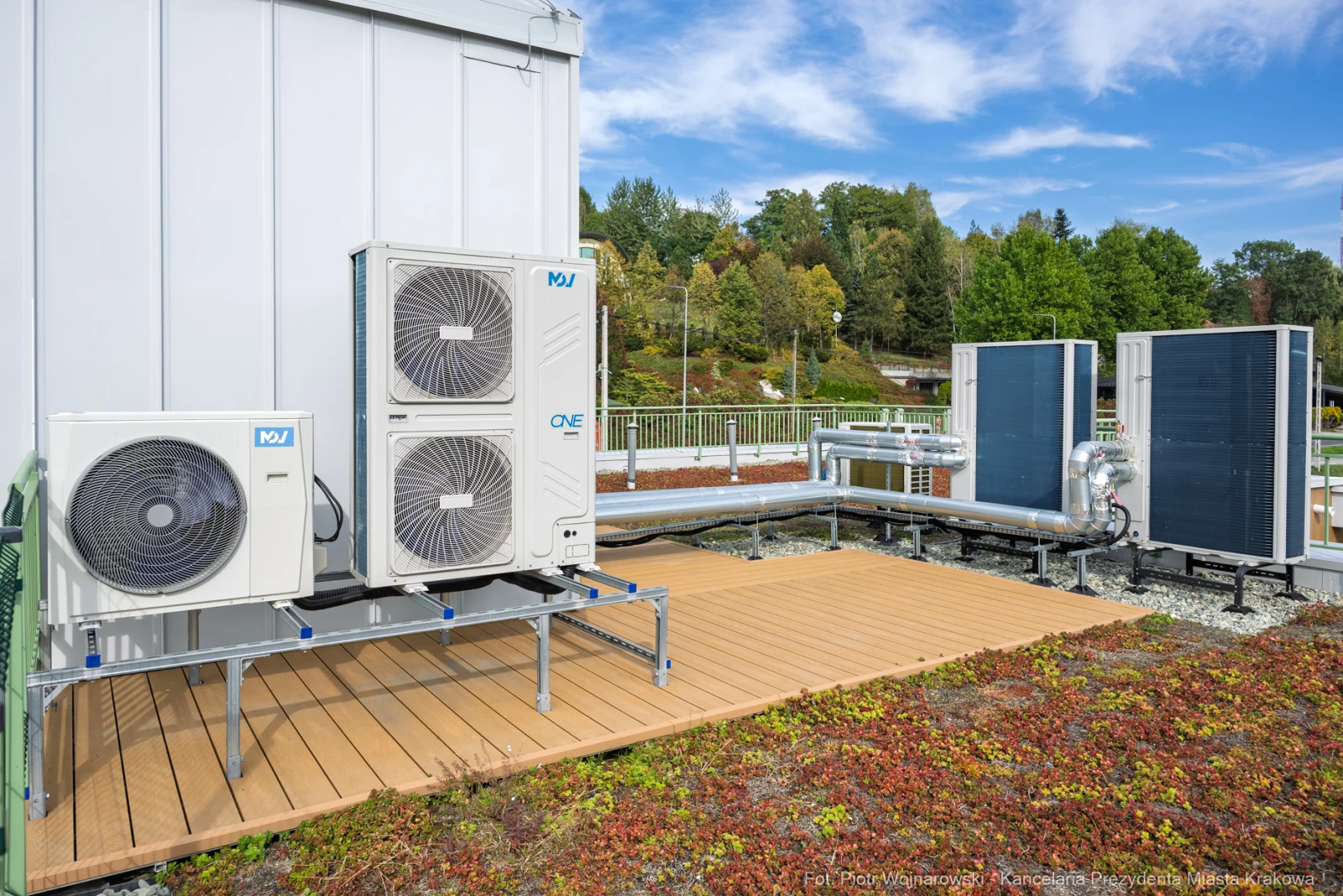 Instalacja systemu klimatyzacji z jednostkami zewnętrznymi i rurami na tle zieleni.  Autor: Piotr Wojnarowski