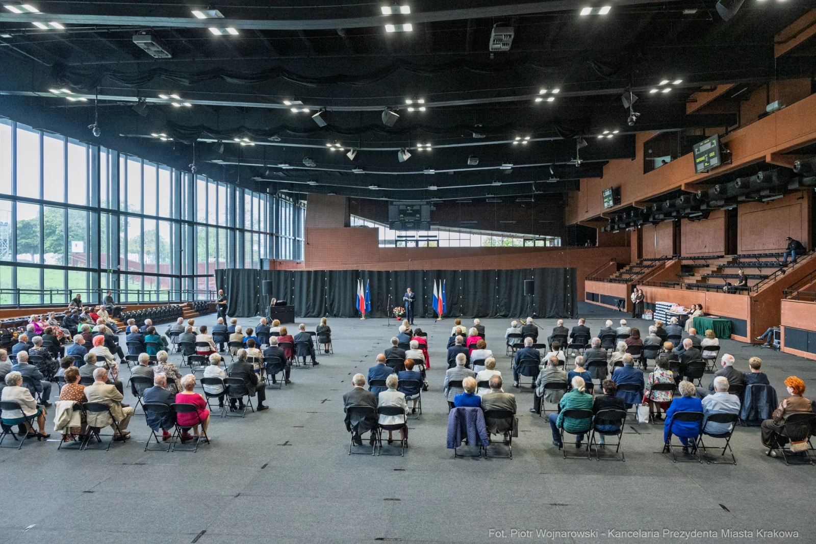 Spotkanie z dużą grupą osób w sali, z flagami w tle.  Autor: Piotr Wojnarowski