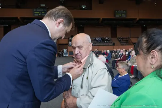 Uroczystość wręczenia odznaczeń, mężczyzna odbiera medal.