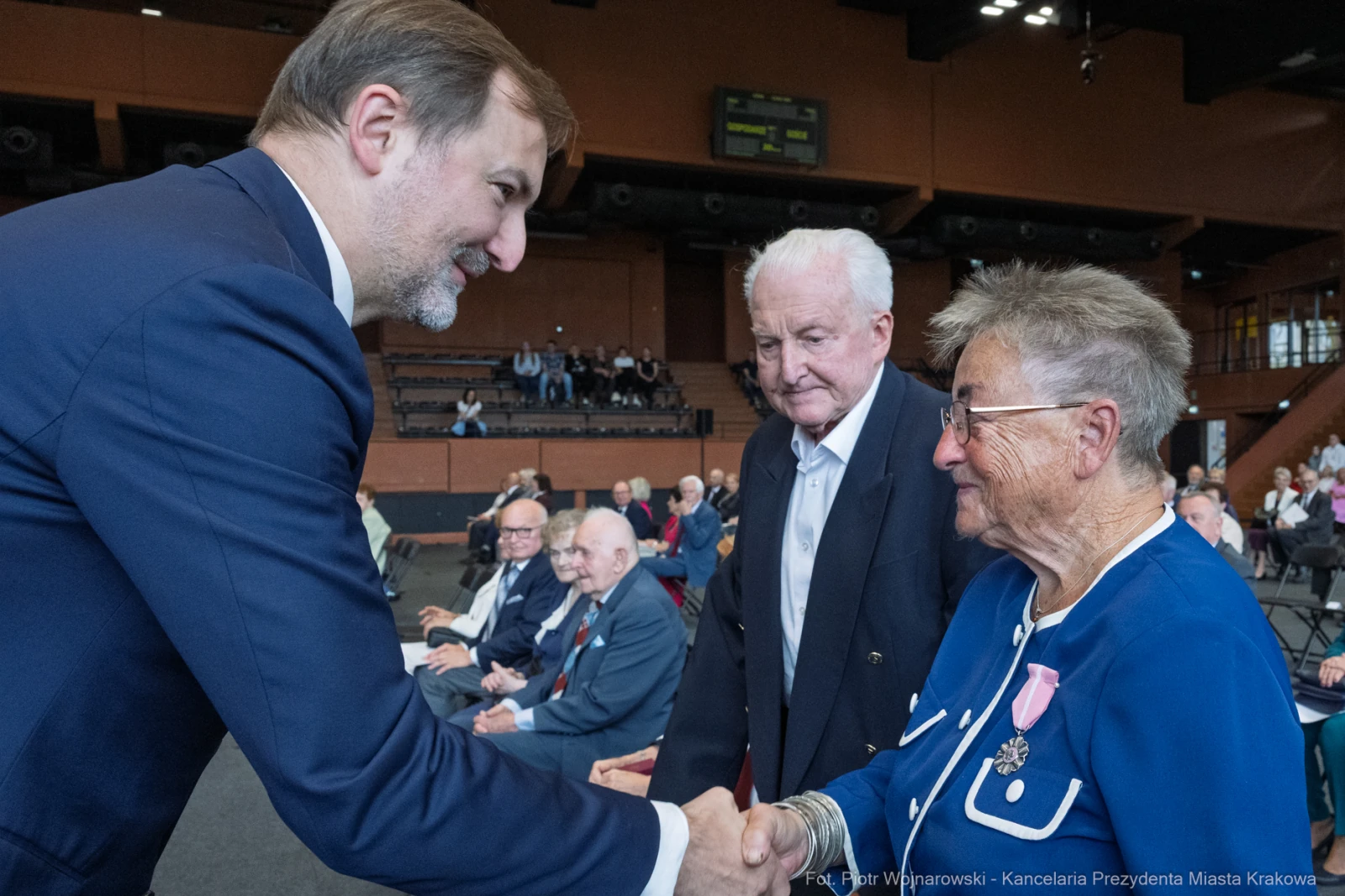 Spotkanie osób starszych z przedstawicielem władz, uściski dłoni i rozmowy.  Autor: Piotr Wojnarowski