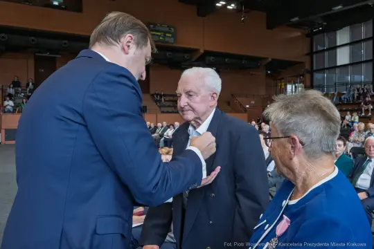 Uroczystość wręczenia odznaczeń, mężczyzna odbierający medal.