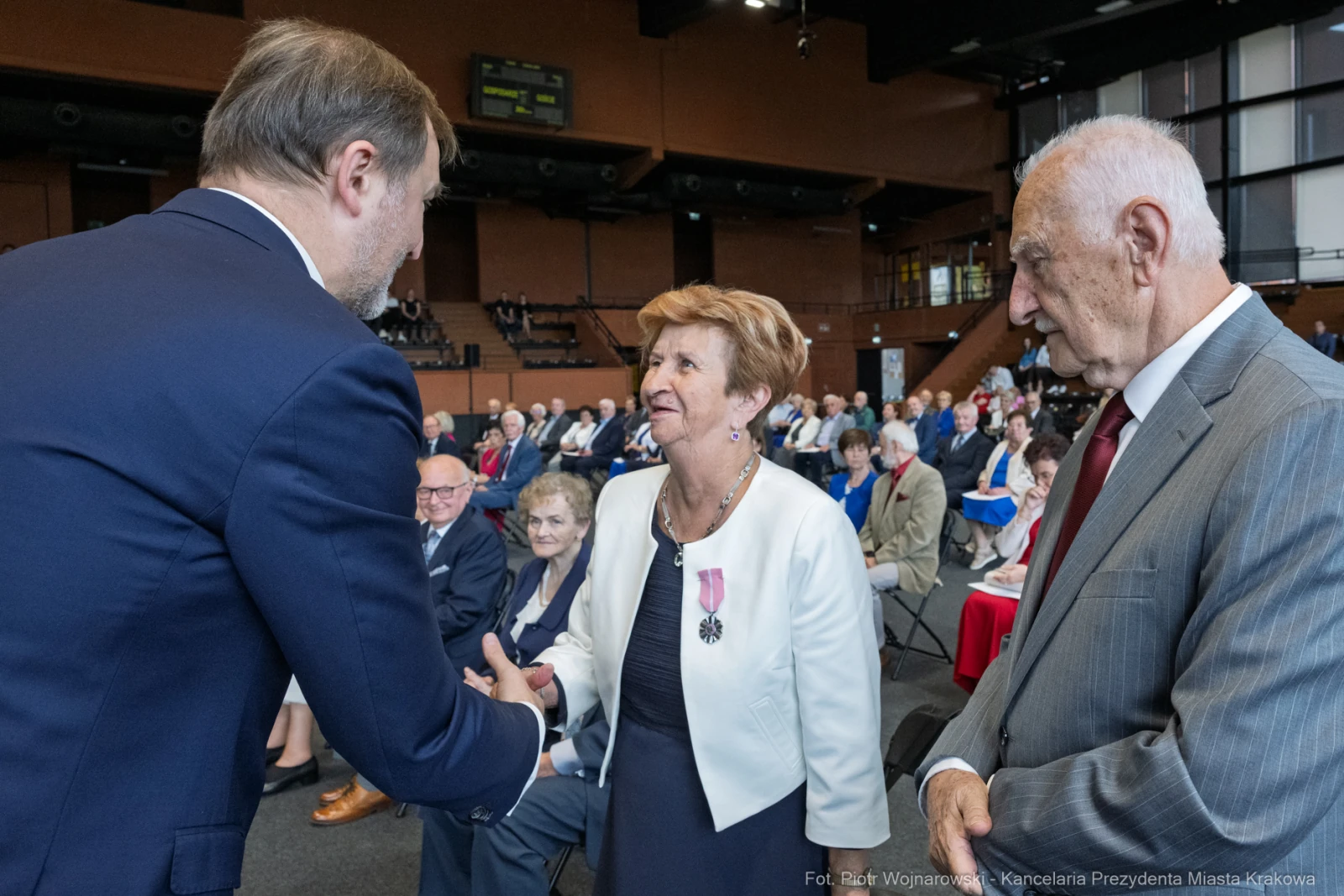 Uroczystość wręczenia odznaczeń w obecności gości i uśmiechniętych uczestników.  Autor: Piotr Wojnarowski