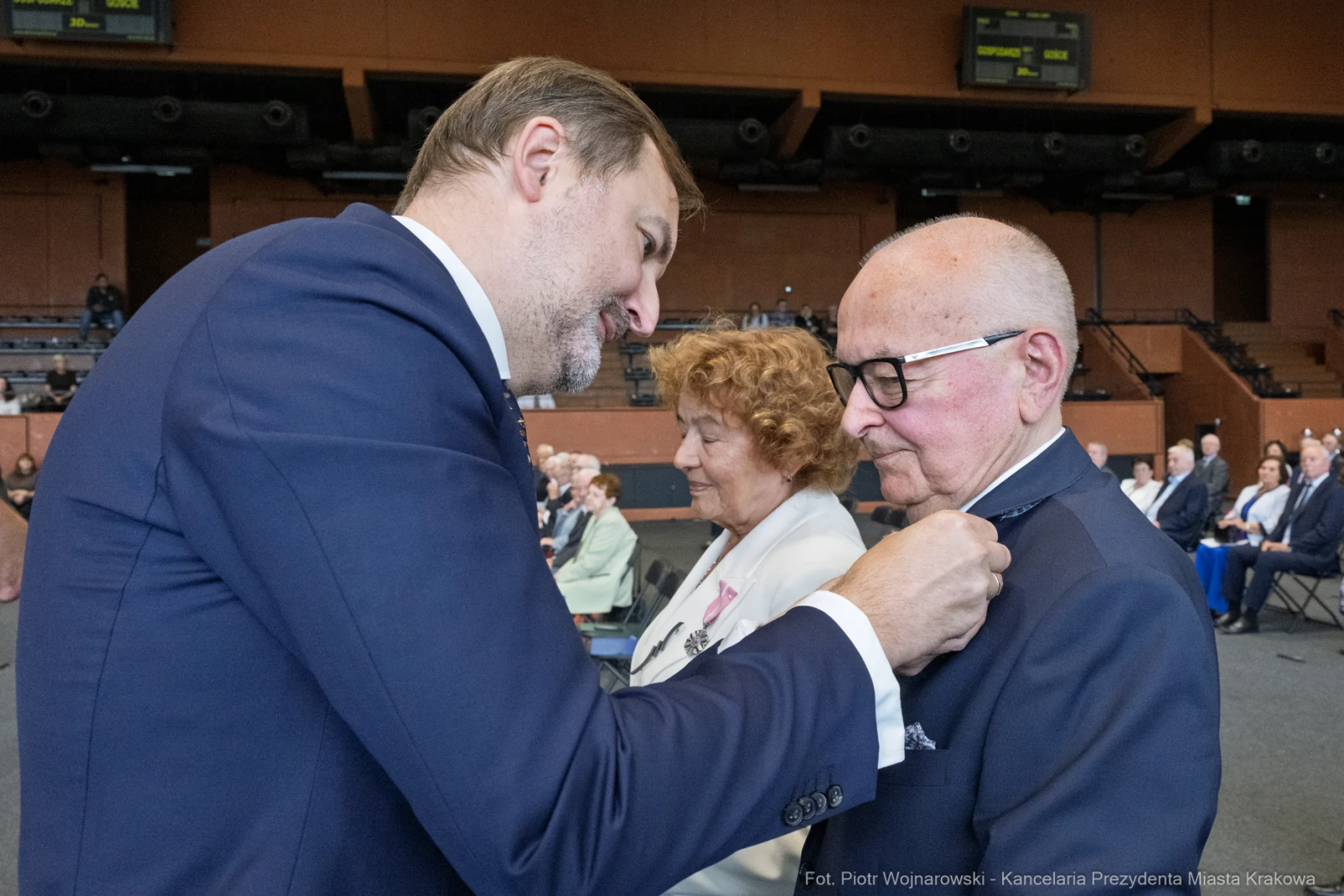 Uroczystość wręczenia odznaczeń, mężczyzna przypina medal do klapy marynarki innego mężczyzny.  Autor: Piotr Wojnarowski