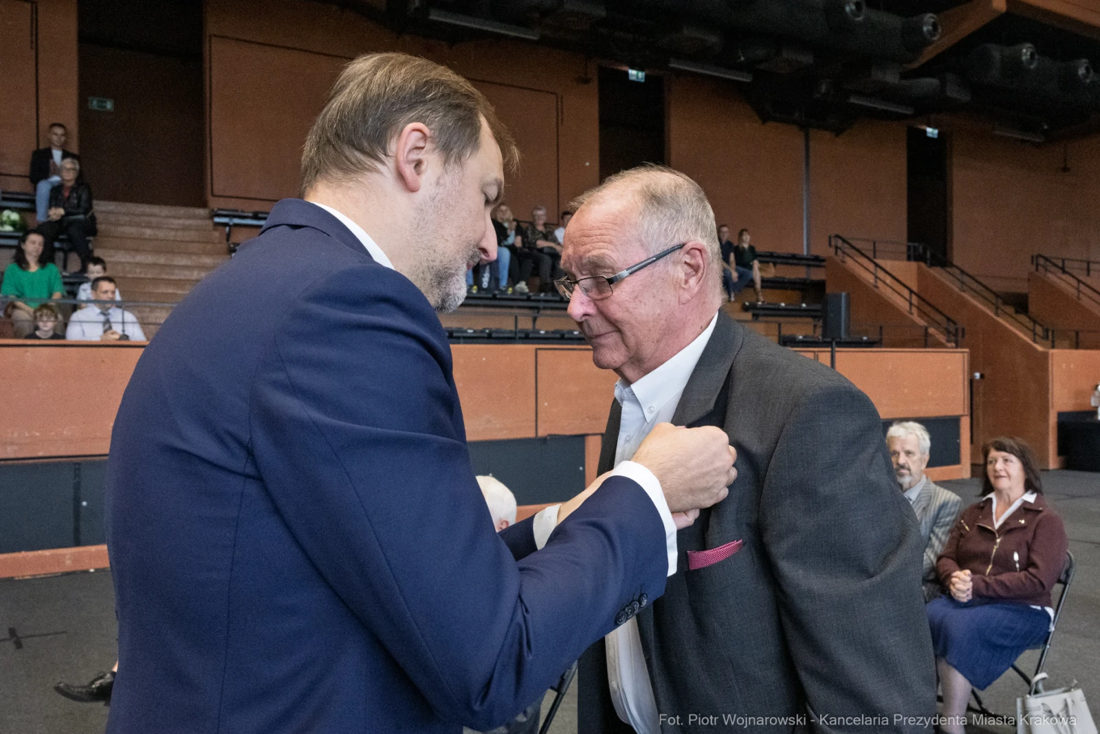 Wręczenie odznaczenia mężczyźnie podczas uroczystości w sali.  Autor: Piotr Wojnarowski