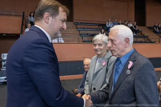 Spotkanie dwóch mężczyzn, jeden z odznaczeniem, w towarzystwie starszej pary.