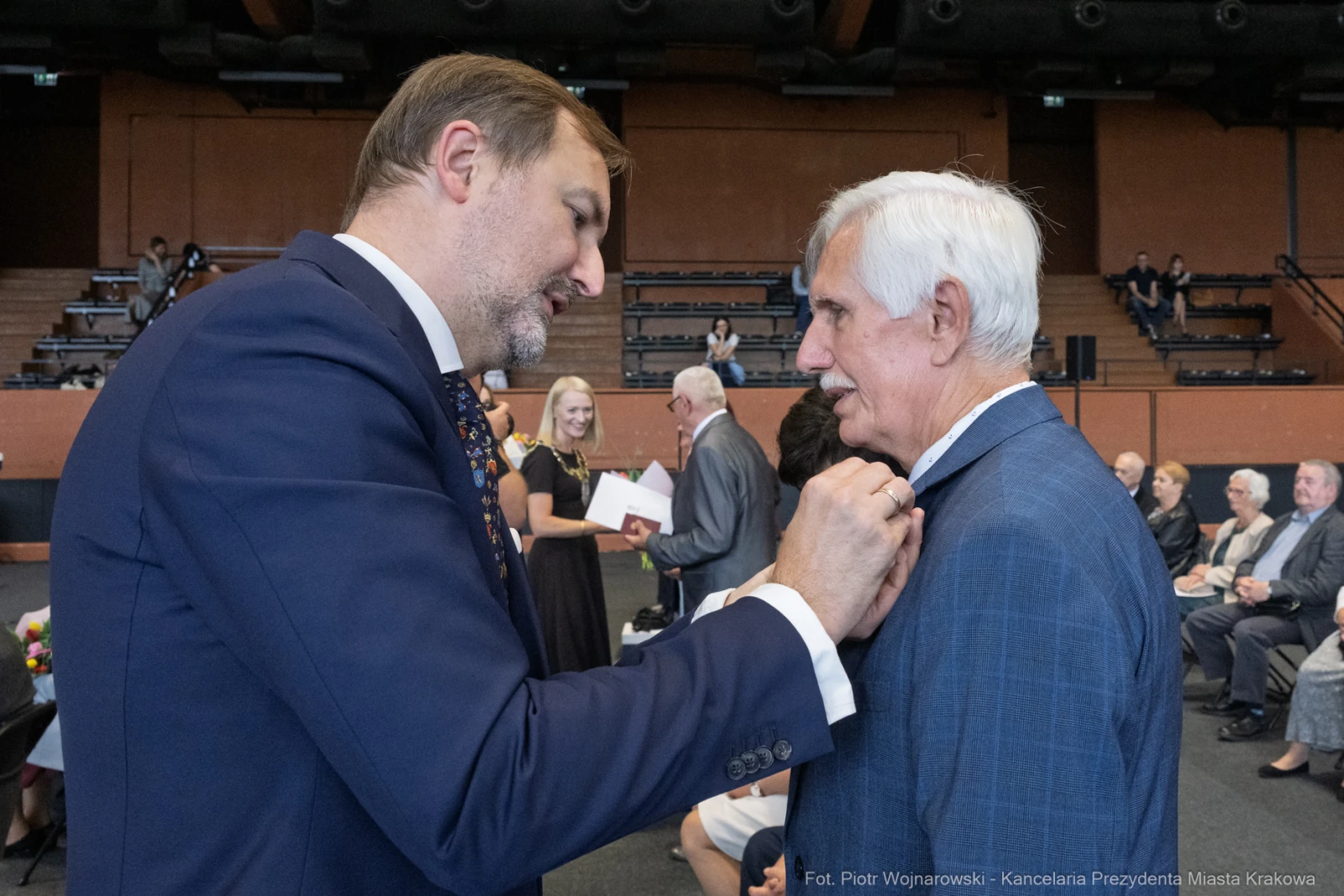 Uroczystość wręczenia odznaczeń, mężczyźni w formalnych strojach rozmawiają.  Autor: Piotr Wojnarowski
