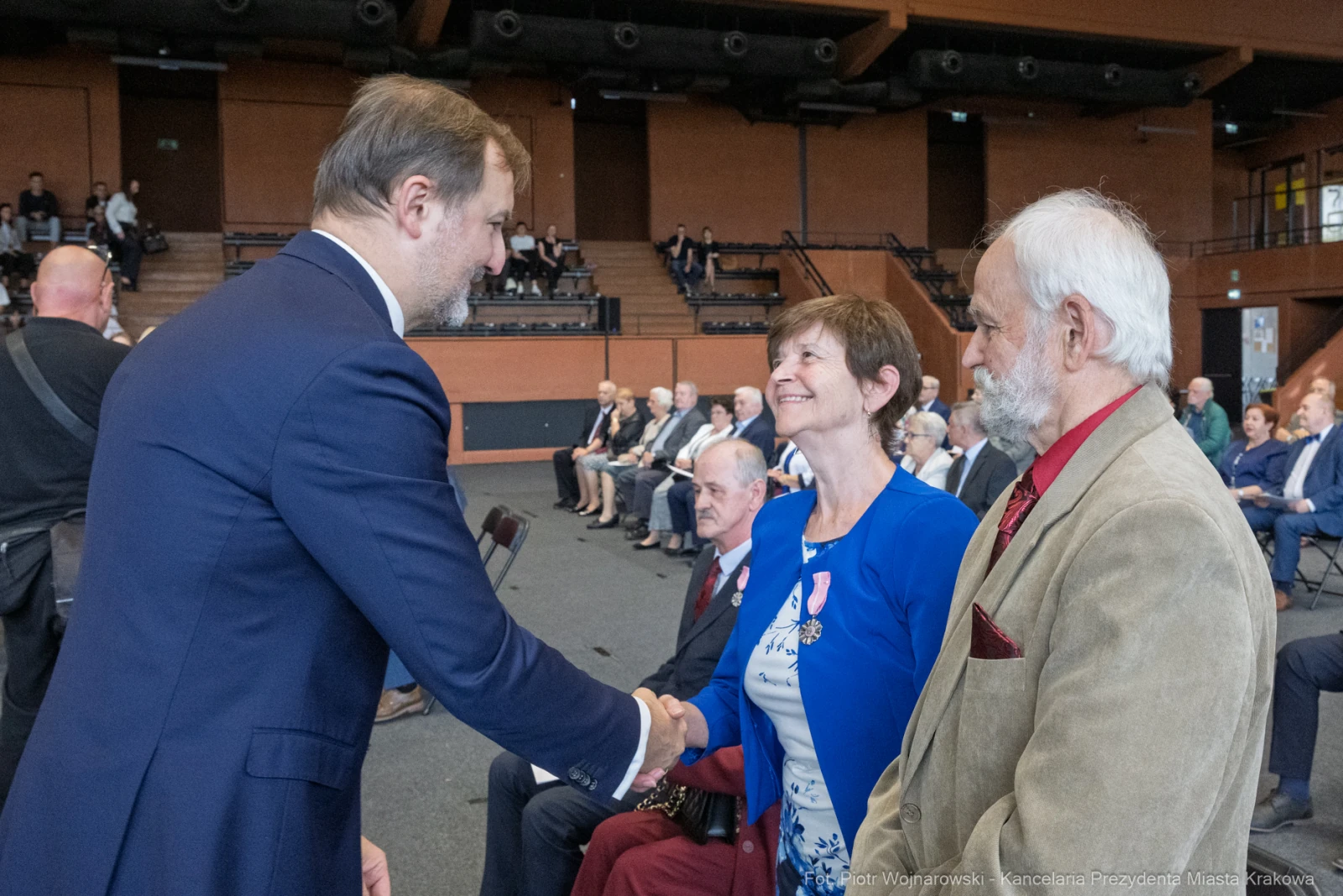 Uroczystość wręczenia odznaczeń, uściski dłoni i uśmiechy uczestników.  Autor: Piotr Wojnarowski
