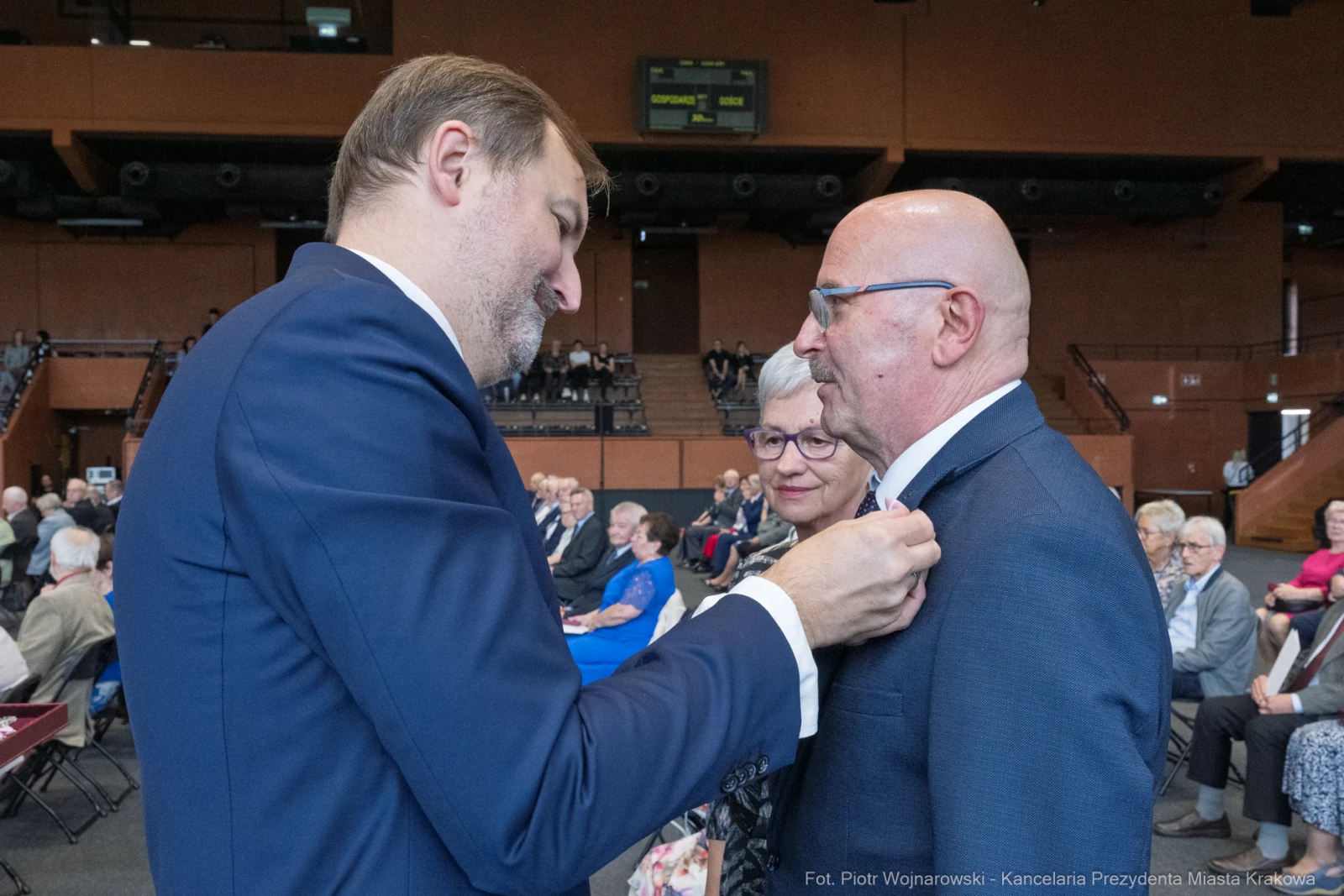 Uroczystość wręczenia odznaczeń, mężczyzna przypina medal innemu mężczyźnie.  Autor: Piotr Wojnarowski