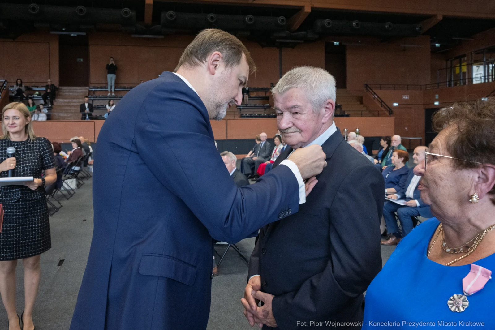 Wręczenie odznaczenia mężczyźnie podczas uroczystości w sali.  Autor: Piotr Wojnarowski