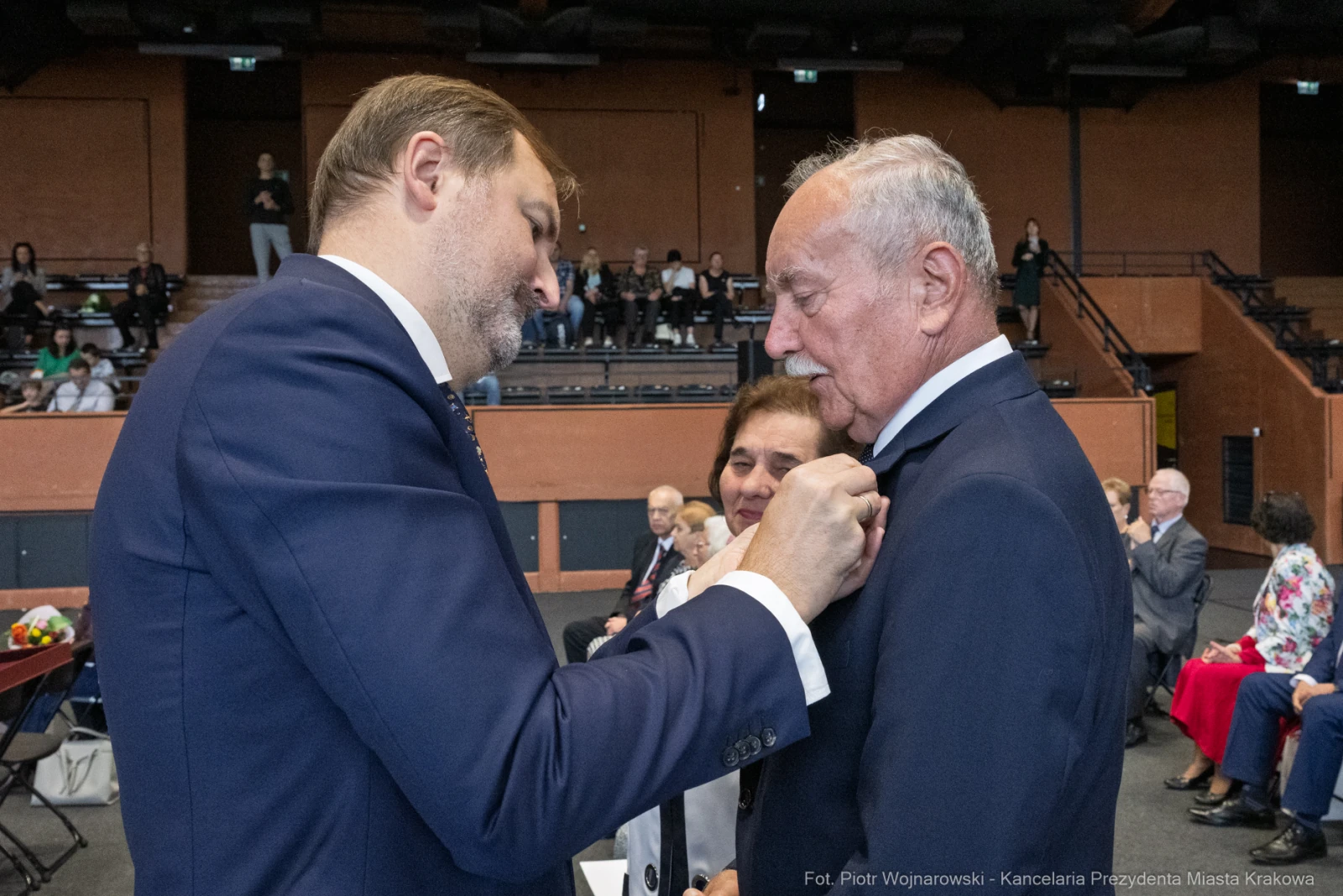 Uroczystość wręczenia odznaczeń, mężczyzna przypina medal do marynarki innego mężczyzny.  Autor: Piotr Wojnarowski