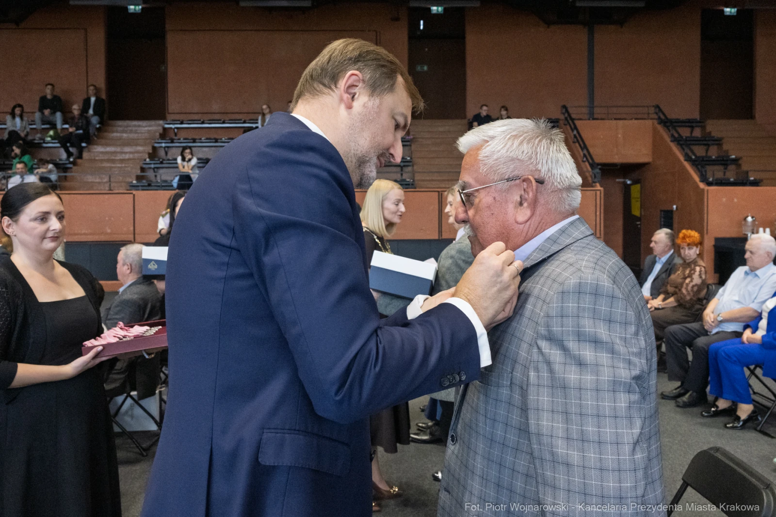 Uroczystość wręczenia odznaczeń, mężczyzna przypina medal innemu mężczyźnie.  Autor: Piotr Wojnarowski