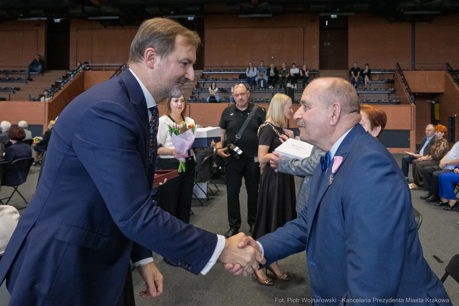 Uścisk dłoni dwóch mężczyzn podczas uroczystości wręczenia nagród.  Autor: Piotr Wojnarowski